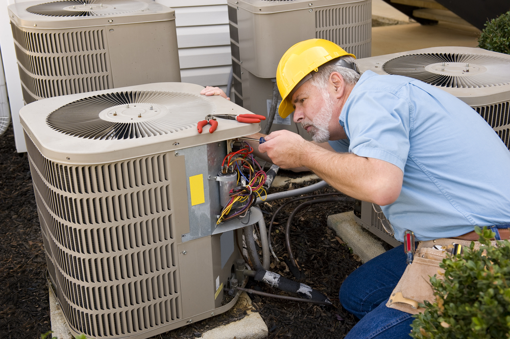 Professional technician from AZ Home Services Group servicing an air conditioning unit in Tempe, Arizona.