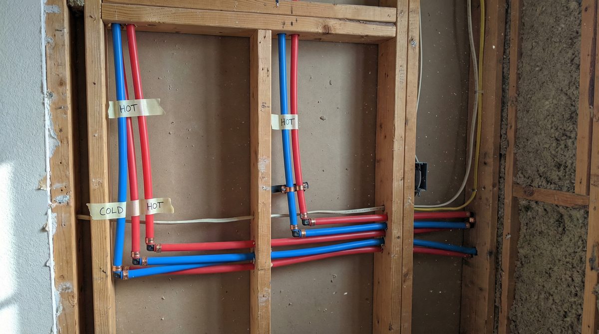 Red and blue PEX tubing installed along wall framing during Scottsdale home repiping